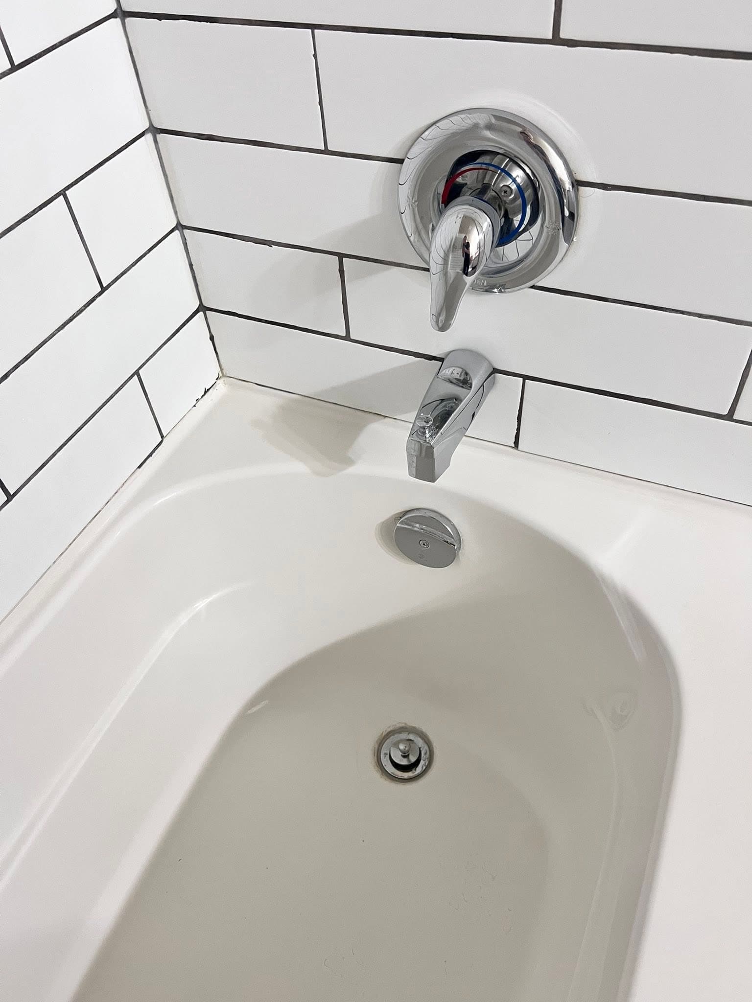 Bathroom bathtub and wall cleaned during standard recurring cleaning service